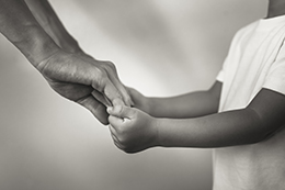 Autonomía relacional en pediatría: adulto sosteniendo la mano a un niño